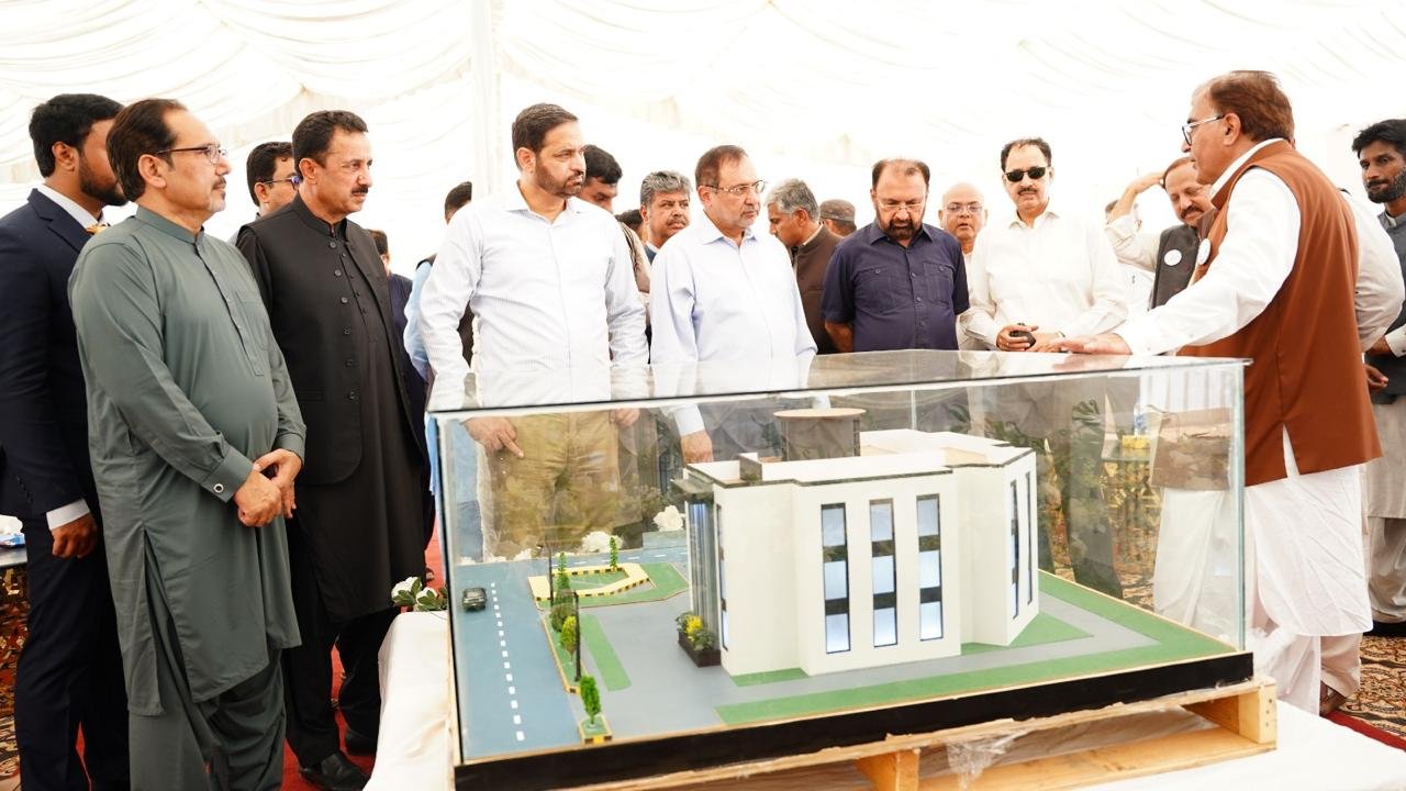 Discussion of the proposed building around Tameer Associates’ architectural model.